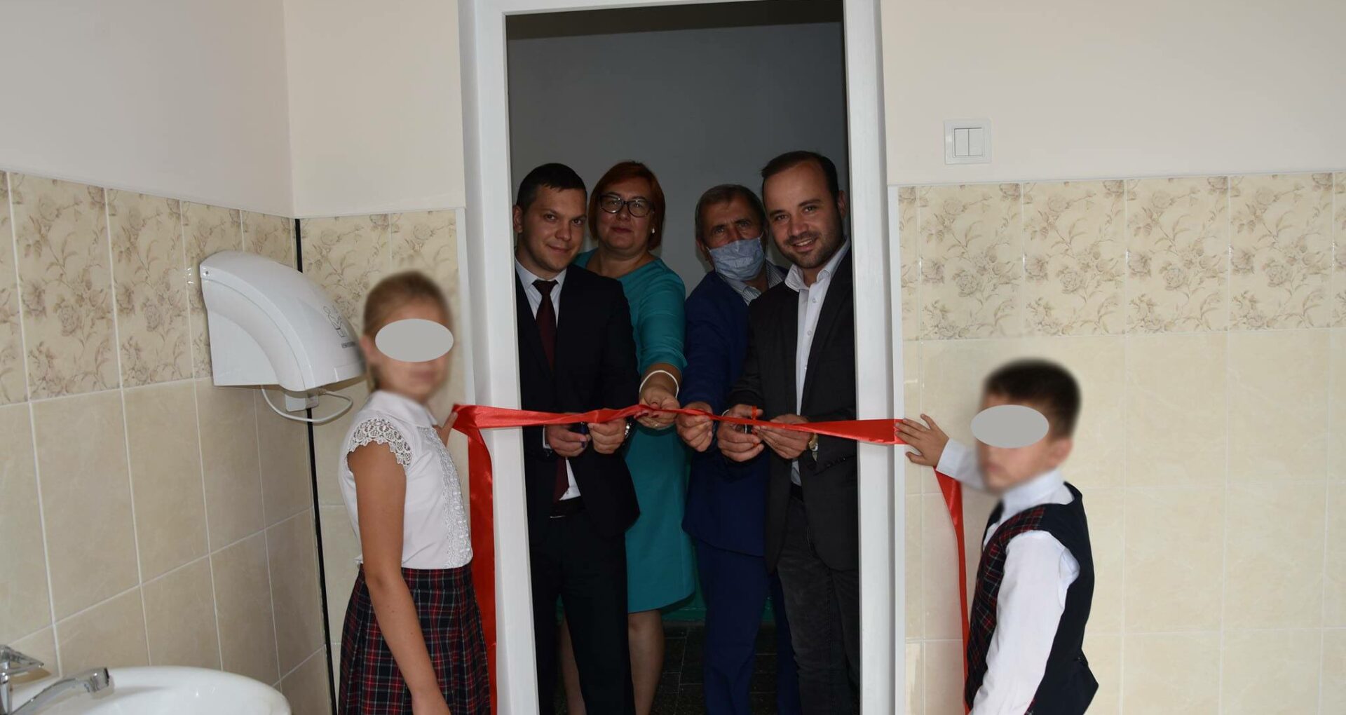 FOTO/ Inaugurare cu fast a unui veceu dintr-un sat din raionul Rîșcani: Un deputat PSRM, președintele raionului și alți oficiali fără măști, alături de doi copii, taie panglica roșie
